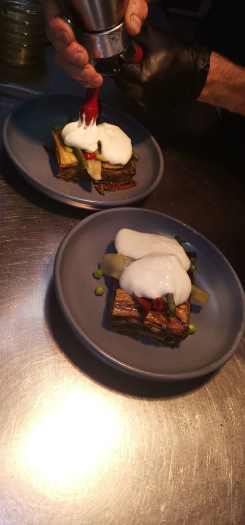 Chef plating gourmet dish with white sauce at Auberge du Pont de l'Alp in Le Monêtier-les-Bains