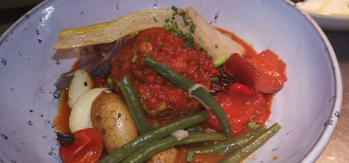 Elegant plated dish at Auberge du Pont de l'Alp featuring roasted vegetables, green beans, and herbs in tomato sauce