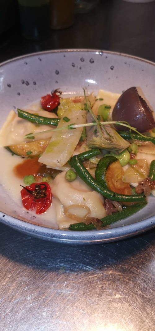 Elegantly plated seafood dish at Auberge du Pont de l'Alp with scallops, vegetables, and red pepper garnish
