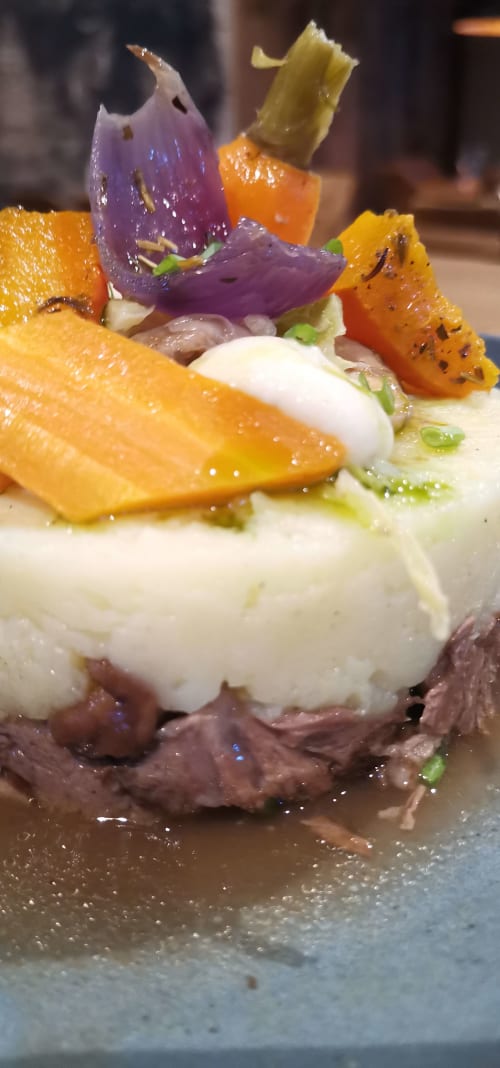Gourmet plated dish at Auberge du Pont de l'Alp featuring roasted vegetables, white cream, and purple eggplant garnish in Le