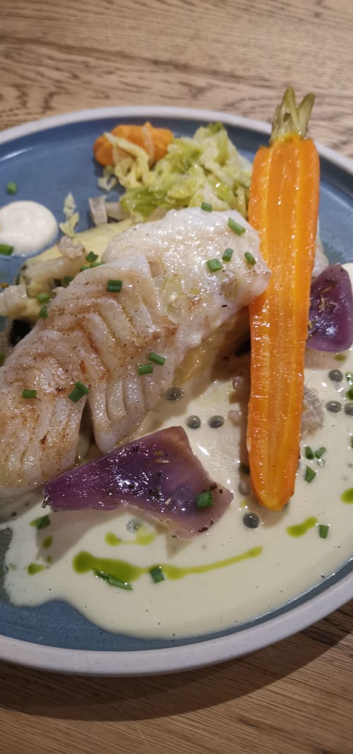 Elegant plated fish dish with creamy sauce, roasted vegetables, and chives at Auberge du Pont de l'Alp