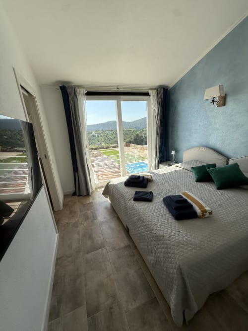Camera da letto Shabby Chic di lusso in Sardegna con vista sul mare, letto matrimoniale, terrazza con piscina e montagne