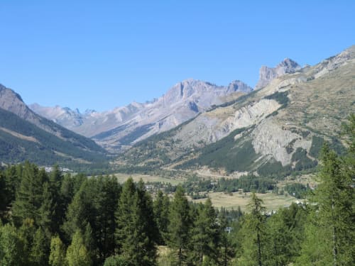 Paysage de vallée alpine avec versants forestiers et pics rocheux au-dessus de Le Monêtier-les-Bains, Alpes françaises