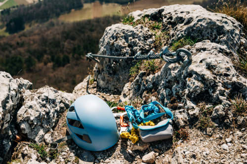 Équipement d'escalade avec casque blanc et corde bleue sur terrain montagneux rocheux près de l'Auberge du Pont de l'Alp, Le Monêtier-les-Bains