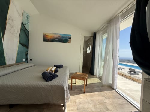 Bright bedroom with double bed, direct pool access, ocean view through glass doors, Torpè Sardinia B&B
