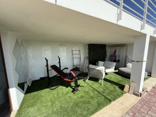 Private veranda at Sardinia Holidays with artificial turf, fitness equipment, and lounge seating in Torpè, Italy