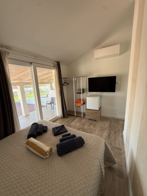 Navy Room double bedroom at Sardinia Holidays with ocean view, private terrace, flat-screen TV, and modern amenities in
