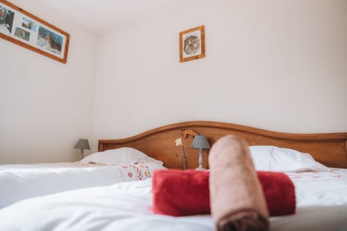 Guest's feet resting on bed at Auberge du Pont de l'Alp hotel in Le Monêtier-les-Bains