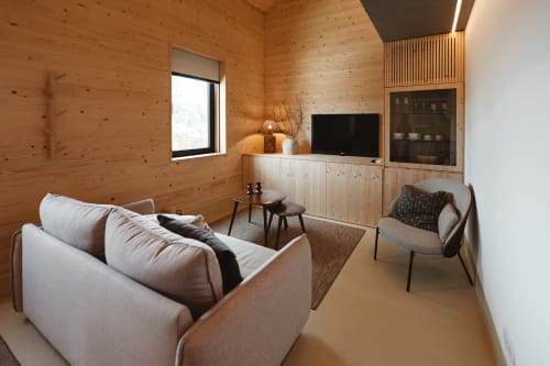 Sala de estar de cabana de madeira moderna na Quinta Das Pirâmides com sofá, TV e design nórdico minimalista em Vila Nova de Famalicão