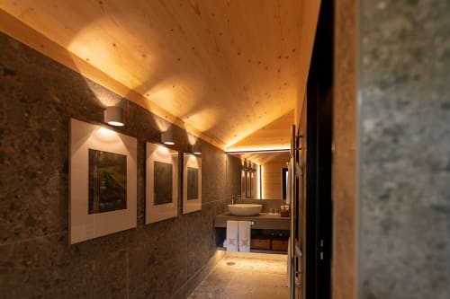 Banheiro moderno na Quinta Das Pirâmides com teto em madeira quente, paredes de pedra escura, obras de arte emolduradas e elegante cuba de cerâmica