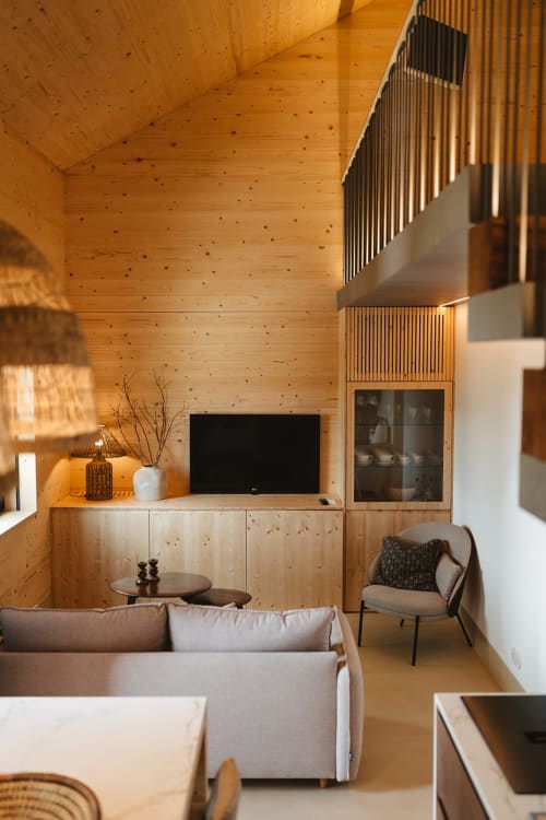 Interior de loft moderno na Quinta Das Pirâmides B&B com sofá, TV e escada para mezzanine em Vila Nova de Famalicão