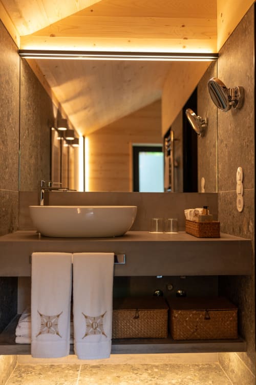 Banheiro moderno na Quinta Das Pirâmides com pia tipo tigela, espelho LED, teto em madeira aquecida e toalhas decorativas