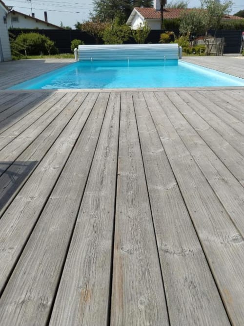 Wooden deck and bright blue private pool with retractable cover at La Pause Landaise in Magescq