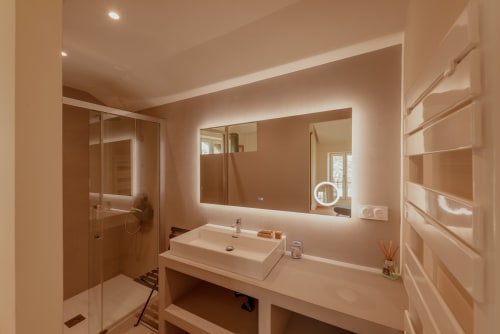 Salle de bain moderne de la villa Vila Cabanes 46 en Lot, France avec miroir éclairant et douche à effet pluie