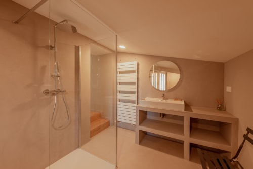 Salle de bain moderne avec douche à l'italienne, sèche-serviettes chauffant, vasque et miroir à la Villa Cabanes 46, demeure de luxe en Lot, France