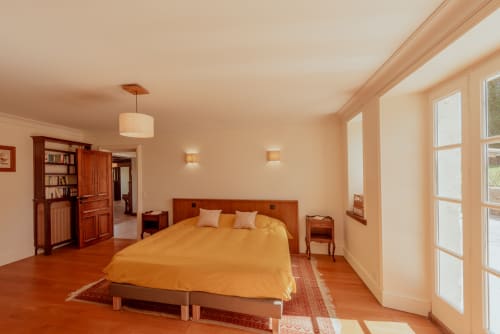 Chambre spacieuse avec mobilier en bois et literie jaune à la villa Vila Cabanes 46 au Montat, Lot, France