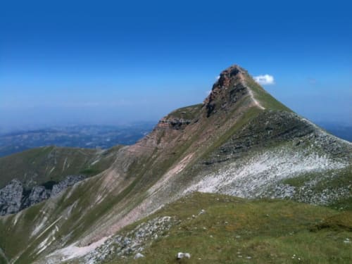Vetta alpina con pendii verdeggianti e terreno roccioso, vista dall'area escursionistica di Amandola, Italia