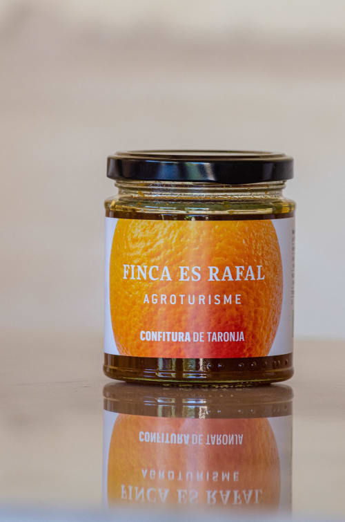 Finca es Rafal orange marmalade jar with black lid and label on white surface