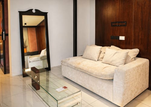 Salon moderne de la Villa Merida Boutique Hotel à Mérida avec canapé crème, miroir à cadre noir, table basse en verre