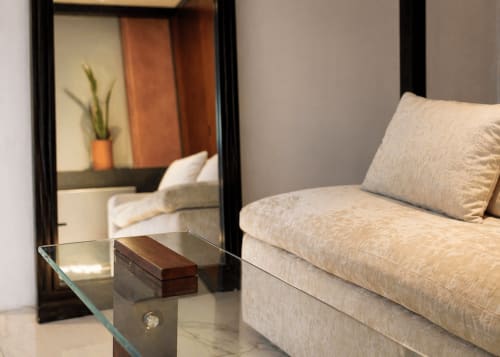 Salon moderne de Villa Merida Boutique Hotel avec canapé beige, table en verre et miroir reflétant la chambre
