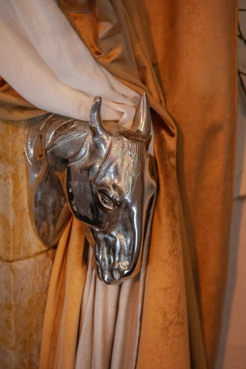 Bronze bull head brooch on ochre fabric at Alombre B&B, Lectoure France