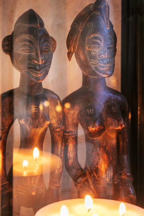 Deux statues africaines en bois éclairées par des bougies à l'Alombre B&B à Lectoure, France