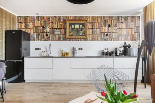 Cuisine moderne à la Maison d'hôtes Alombre à Lectoure : mobilier blanc, électroménagers noirs et mur bibliothèque décoratif