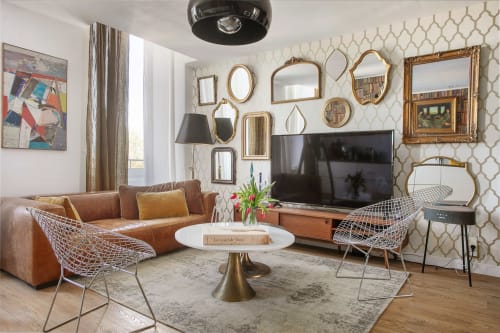 Salon moderne de l'Alombre B&B à Lectoure, canapé cuir cognac, miroirs géométriques, style années 50