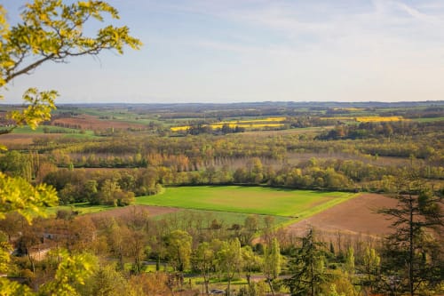 Paysage vallonné de la campagne française près de Lectoure avec champs verts et feuillages automnaux