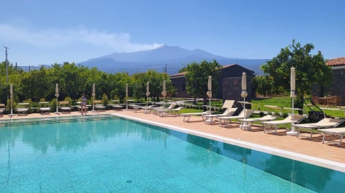 Agriturismo Lumia Resort pool with loungers, umbrellas, and Mount Etna view in Riposto, Sicily
