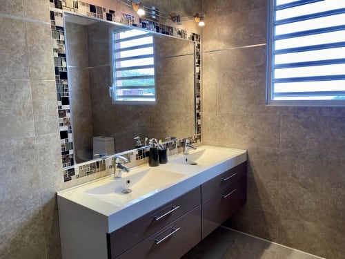 Salle de bain moderne avec double vasque, meuble sombre et miroir à cadre bleu donnant sur la mer des Caraïbes à Villa Bell'ô, Bouillante