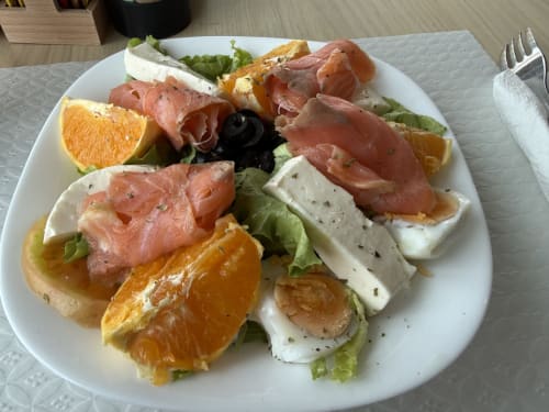 Elegant breakfast plate at Golden Mermaid Villa with smoked salmon, fresh mozzarella, citrus, olives, and greens