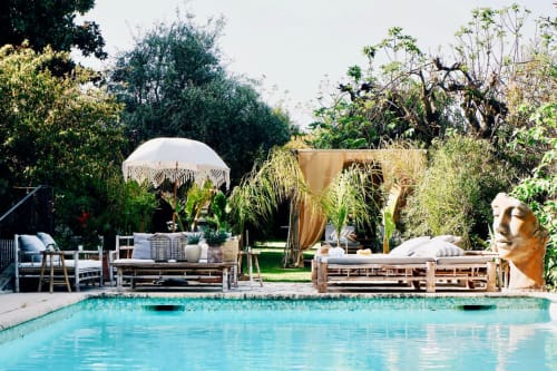 Élégante piscine de la Bastide Aïna à Grasse avec espaces de détente, parasols et jardins luxuriants