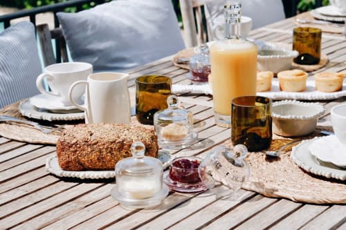Petit-déjeuner en terrasse à Bastide Aïna, Grasse avec viennoiseries, café, confiture et vin sur table en bois