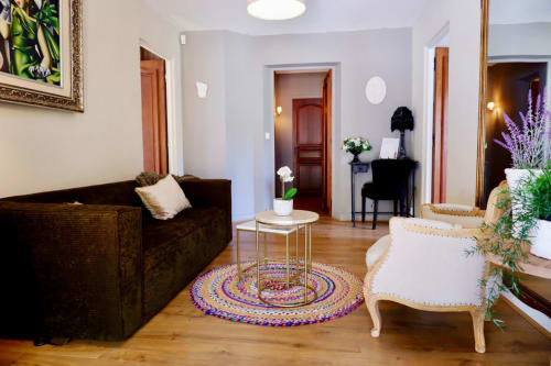 Suite Bastide Aïna à Grasse avec canapé sombre, tapis coloré et mobilier élégant