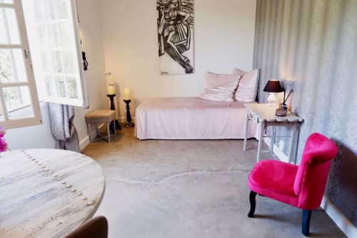 Suite d'inspiration Molinard à la Bastide Aïna, Grasse : chambre lumineuse avec lit rose, fauteuil rose vif et vue montagne