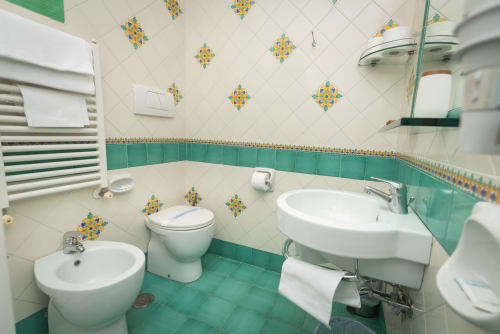 Bagno luminoso turchese e panna con doppio lavabo, WC e bidet a Casa Mannini B&B a Maiori