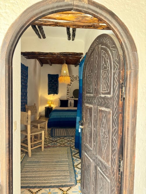 Entrée en arc à la chambre rustique du Riad Eucalyptus avec porte en bois sculpté et décoration marocaine traditionnelle