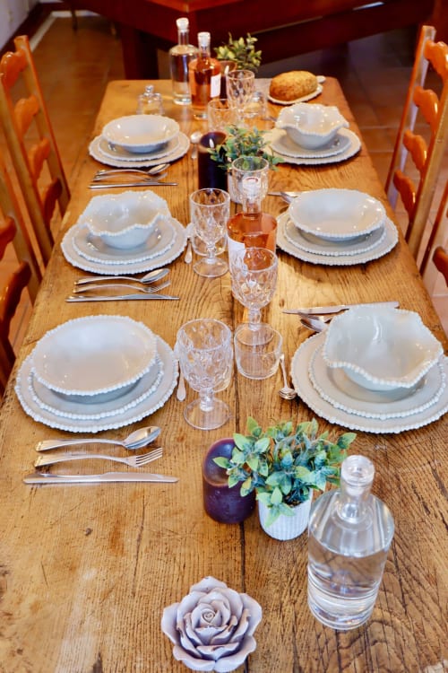 Table élégante à la Bastide Aïna à Grasse avec couverts, verres en cristal et compositions florales fraîches