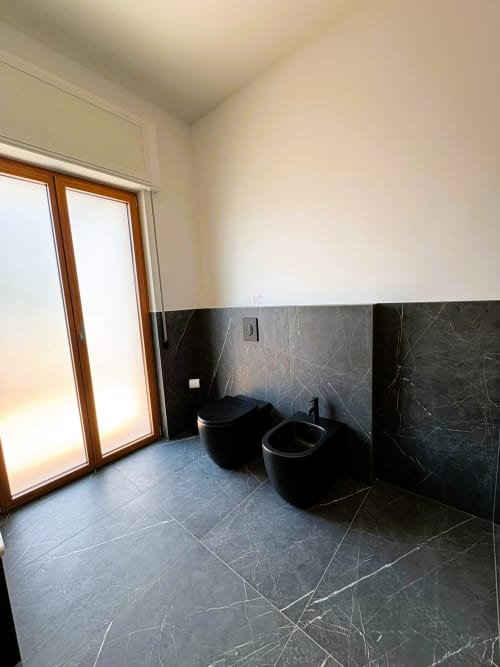 Bagno moderno nella suite Cavour Deluxe dell'hotel Newhouse a Bari con piastrelle di marmo nero