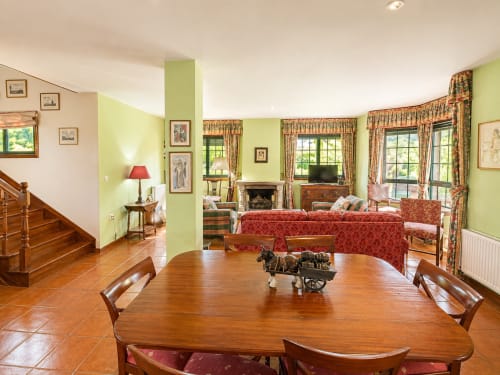 Amplio comedor de villa con mesa de madera, vistas al jardín de la casa. As Landras, Tomiño. Galicia