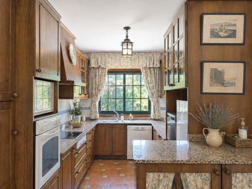 Cocina elegante en villa As Landras, Baiona, con muebles de madera, encimeras de granito y vistas al río