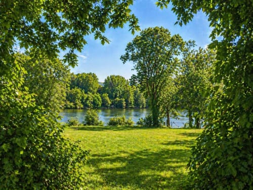 Exuberante sendero ajardinado que enmarca la vista del río Miño en la villa As Landras, Tomiño