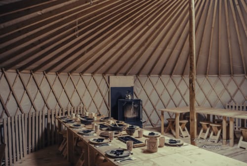 Intérieur de yourte aménagée en salle à manger à La Yourte Un Autre Monde au Hohwald, avec table dressée et chaises en bois