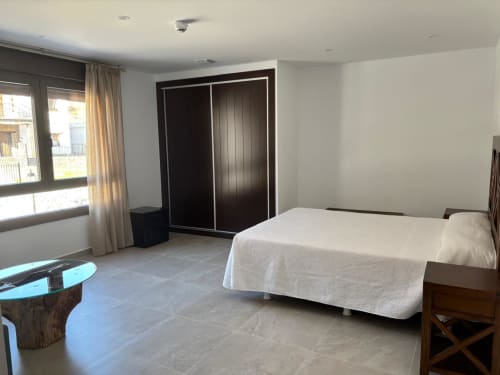 Spacious double superior bedroom at Hotel Mulhacén Trevélez with bed, dark wardrobe, window, and modern amenities