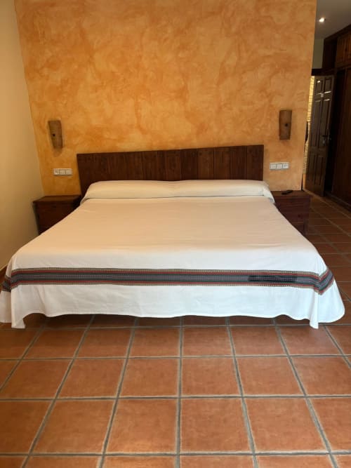 Cama de Junior Suite con ropa de cama blanca en Hotel Mulhacén Trevélez, Granada, con suelo de baldosa de barro y textura naranja