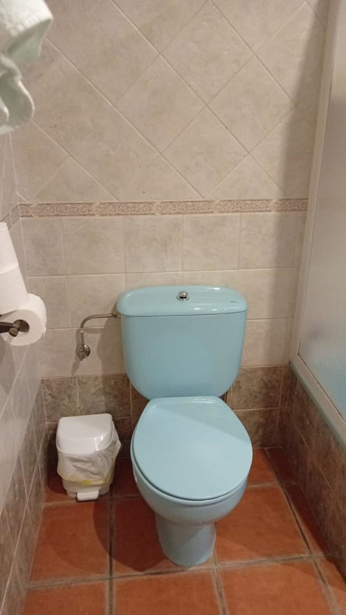 Light blue toilet with bidet in tiled bathroom at Hotel Mulhacén Trevélez, Granada