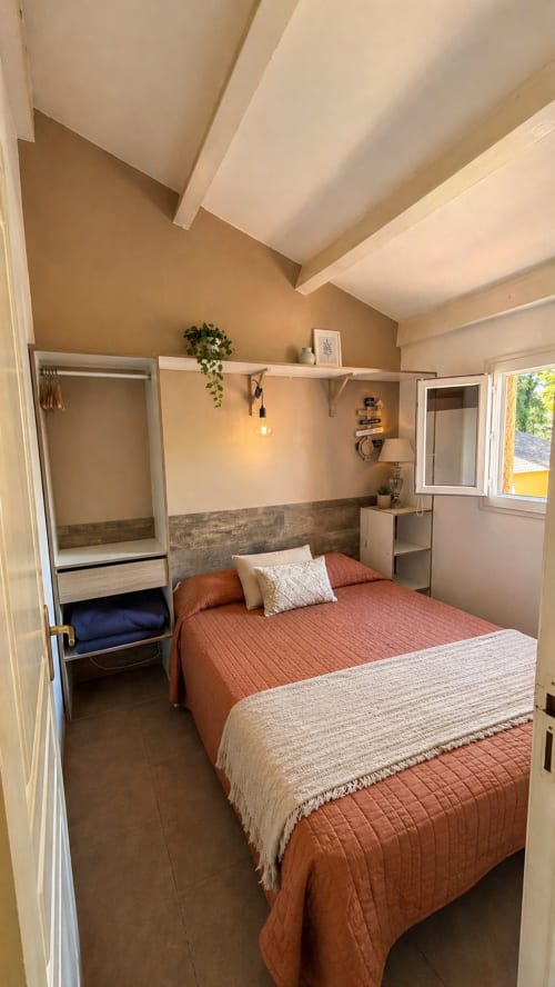 Camera accogliente dell'hotel Le Maquis Plage con letti gemelli, travi in legno e dettagli in terracotta a Poggio-Mezzana