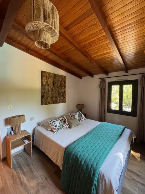 Chambre moderne de la Suite Pétanque à la Maison Terre de Lune, Mondragon avec plafond en bois et vue sur la piscine