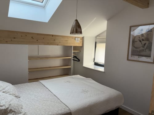 Chambre moderne de l'auberge En si bon chemin avec lit, étagères bois, lucarne et lampe suspendue au Monastier-sur